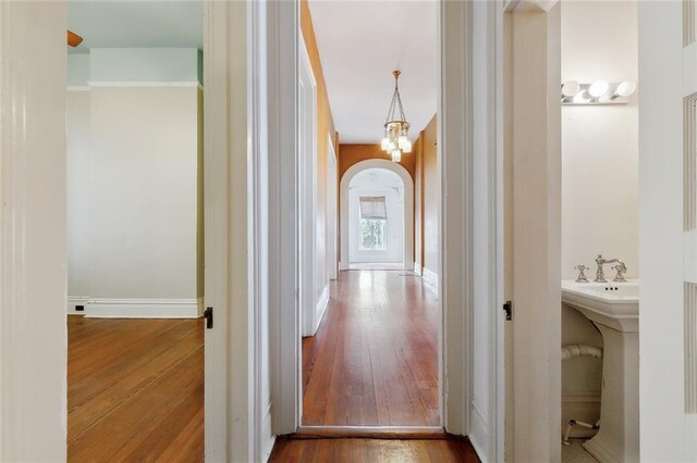 corridor featuring a chandelier and hardwood / wood-style floors