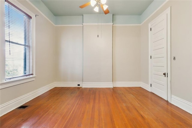 empty room with ceiling fan and hardwood / wood-style floors