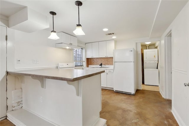 kitchen featuring a breakfast bar area, kitchen peninsula, white fridge, and white cabinetry