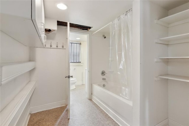 bathroom featuring toilet and shower / tub combo with curtain