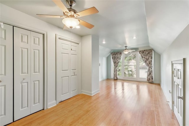 7917 Sycamore St, New Orleans, LA 70118 - unfurnished bedroom with two closets, baseboards, light wood-style floors, vaulted ceiling, and ceiling fan