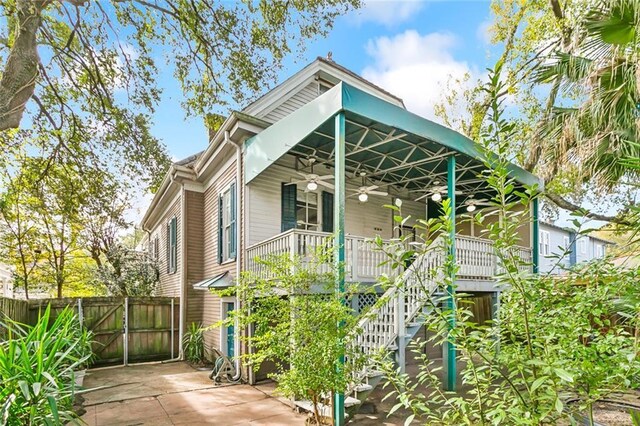 7917 Sycamore St, New Orleans, LA 70118 - view of front facade featuring a ceiling fan, fence, stairs, covered porch, and a patio area