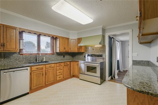 kitchen with appliances with stainless steel finishes, wall chimney range hood, a textured ceiling, ornamental molding, and sink