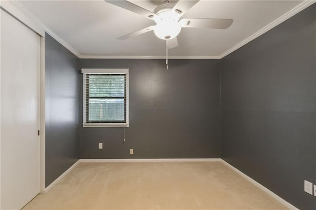 carpeted empty room with ceiling fan and ornamental molding