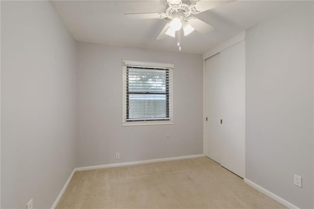 unfurnished room featuring light carpet and ceiling fan