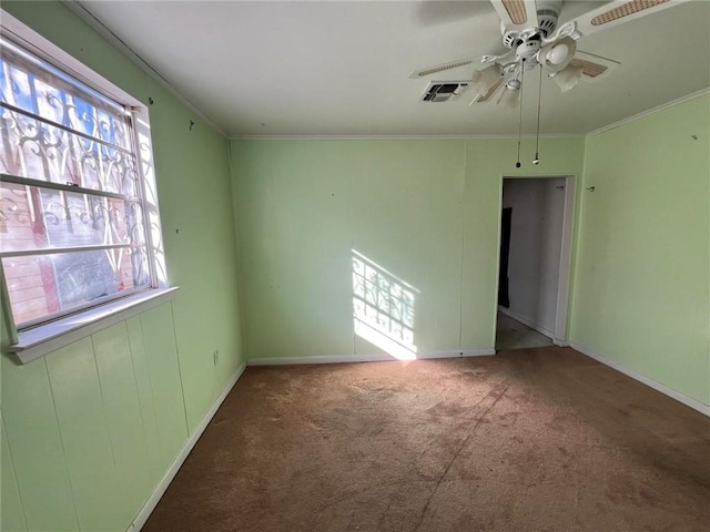 carpeted spare room featuring ceiling fan and ornamental molding