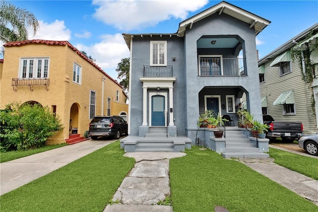 view of front of house featuring a front lawn and a balcony