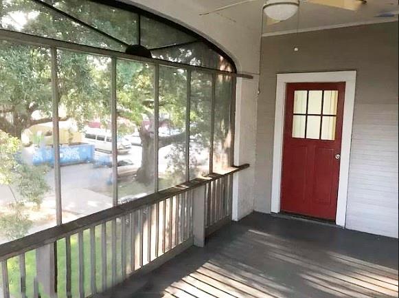 unfurnished sunroom with ceiling fan