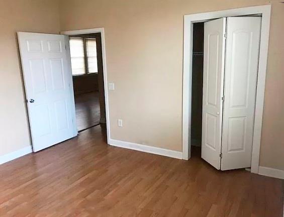 unfurnished bedroom featuring dark hardwood / wood-style floors and a closet