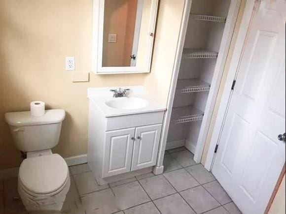 bathroom featuring toilet, tile patterned flooring, and vanity