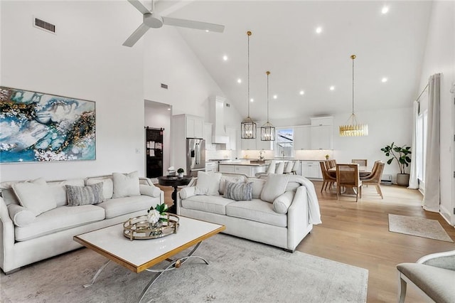 1012 Athania Pkwy, Metairie, LA 70001 - living area featuring high vaulted ceiling, light wood-style floors, ceiling fan, a chandelier, and recessed lighting