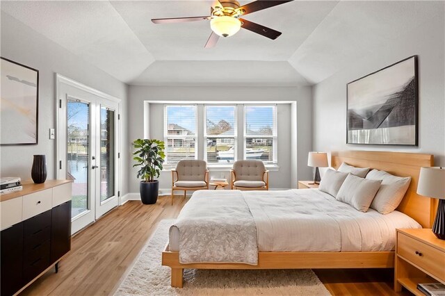 bedroom with ceiling fan, access to exterior, vaulted ceiling, and light wood-type flooring