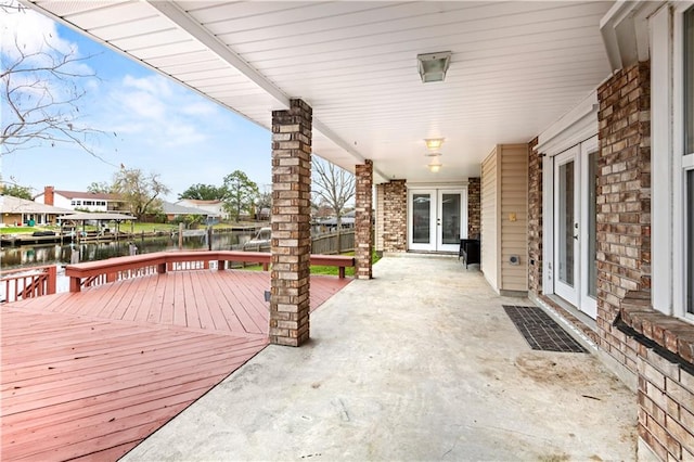 wooden deck featuring a water view and french doors