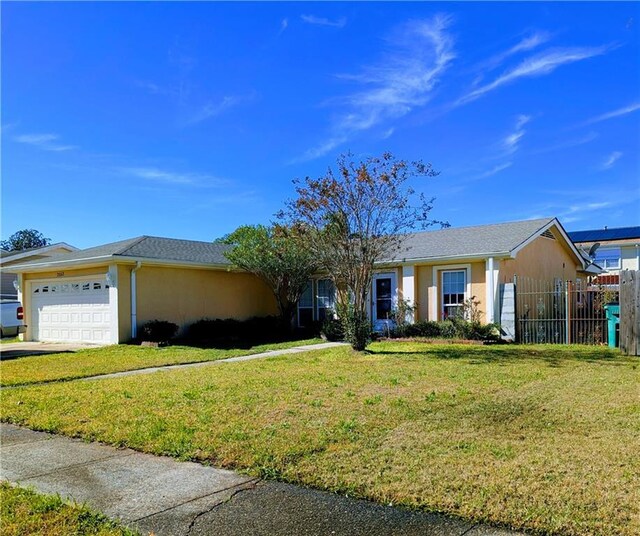 ranch-style home with a garage and a front lawn