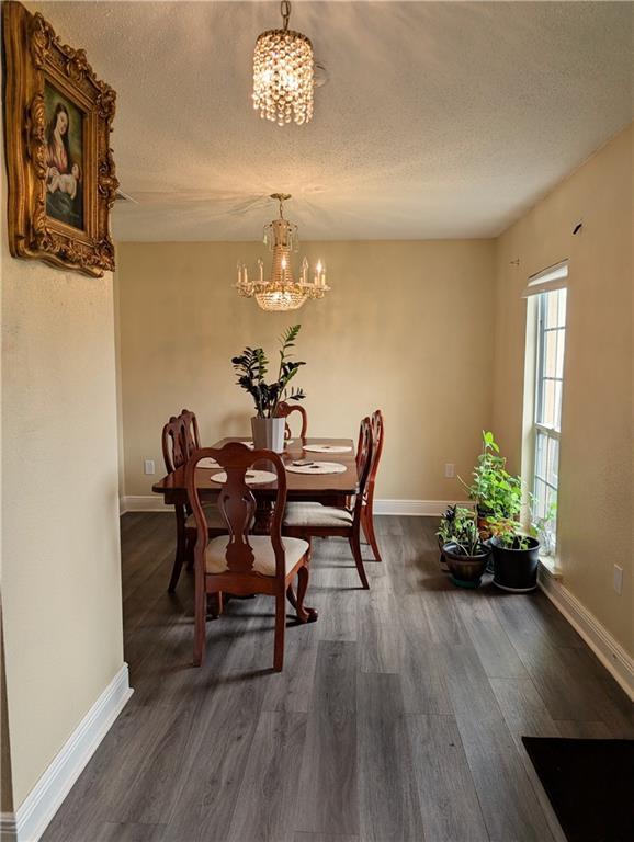 kitchen with light stone countertops, a textured ceiling, stainless steel appliances, and light wood-type flooring