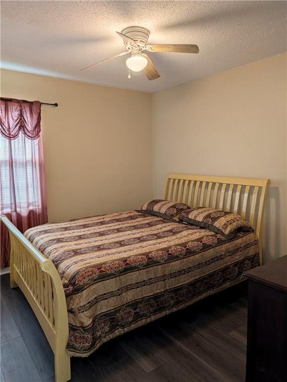 bedroom featuring ceiling fan, wood-type flooring, and a textured ceiling