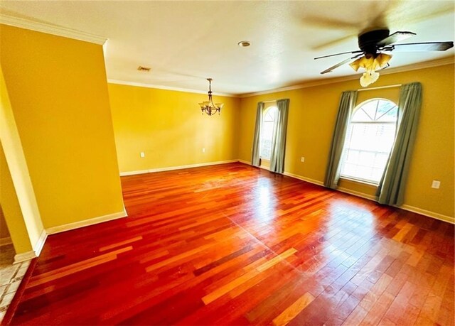 spare room featuring ceiling fan with notable chandelier, crown molding, and hardwood / wood-style floors