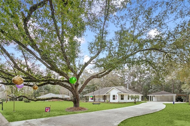 view of front of house featuring a front yard, a garage, a carport, and an outdoor structure