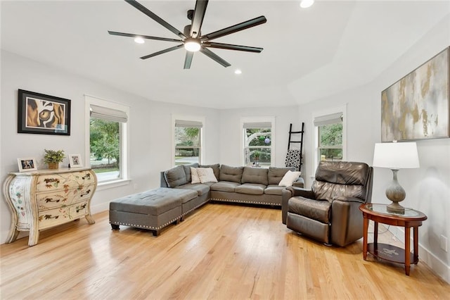 living room featuring ceiling fan, plenty of natural light, and light hardwood / wood-style floors