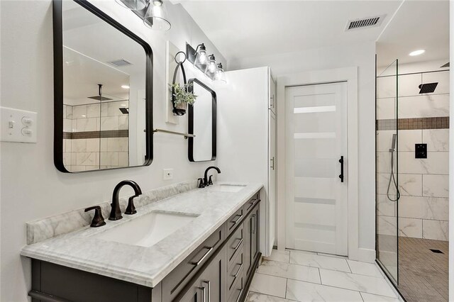 bathroom with tiled shower and vanity