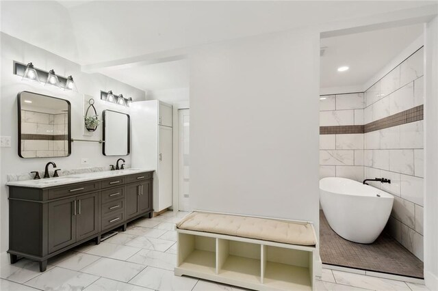 bathroom featuring tile walls, a bathtub, and vanity