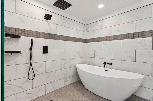 bathroom with tile patterned flooring, tile walls, and separate shower and tub