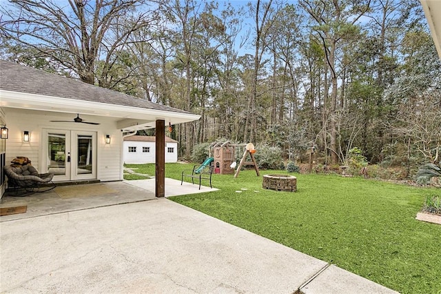 view of yard with an outbuilding, french doors, a playground, a patio, and ceiling fan