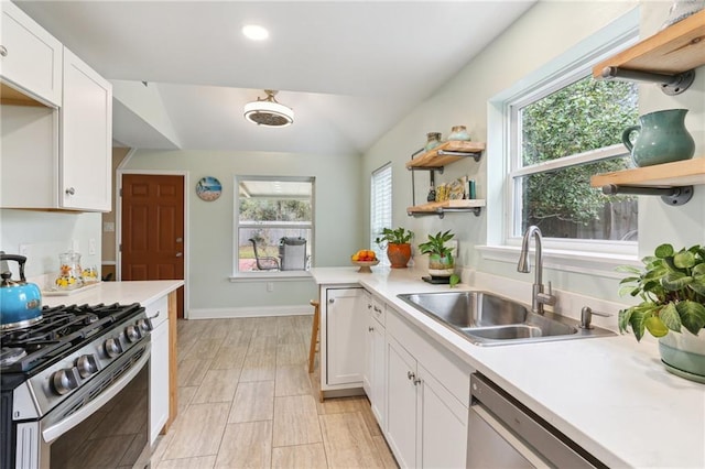 kitchen featuring a wealth of natural light, appliances with stainless steel finishes, white cabinets, and sink