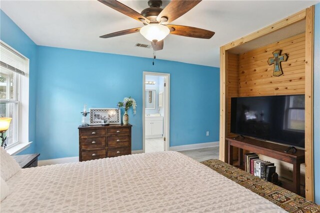 carpeted bedroom featuring ceiling fan, connected bathroom, and multiple windows