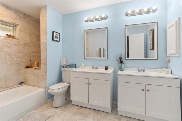 full bathroom with toilet, vanity, and tiled shower / bath