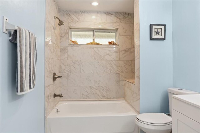 full bathroom featuring toilet, tiled shower / bath, and vanity