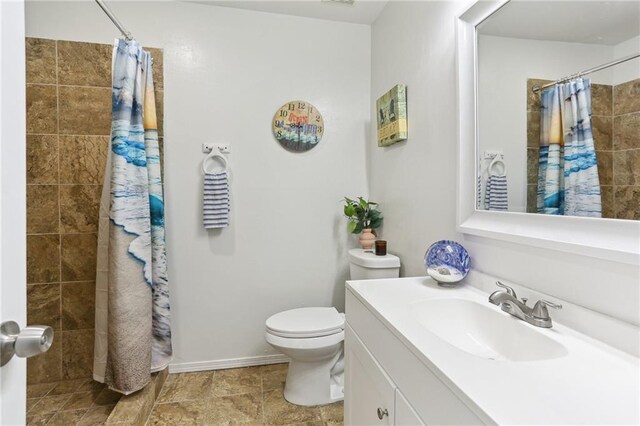 bathroom with curtained shower, toilet, and vanity