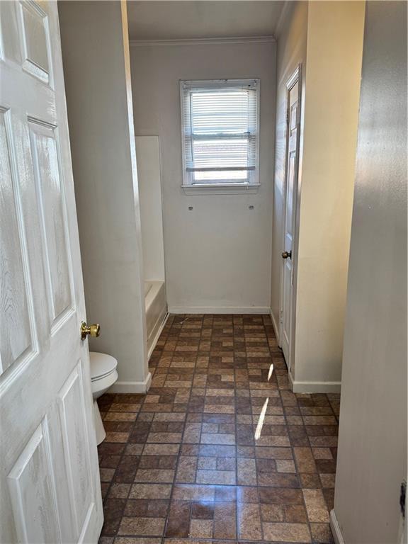 bathroom with toilet and ornamental molding