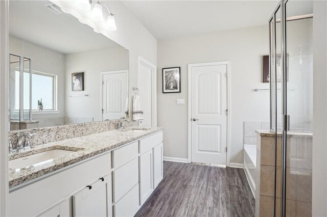 bathroom featuring wood-type flooring, vanity, and separate shower and tub