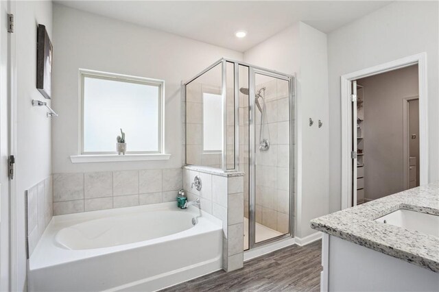 bathroom featuring vanity, plus walk in shower, and hardwood / wood-style flooring