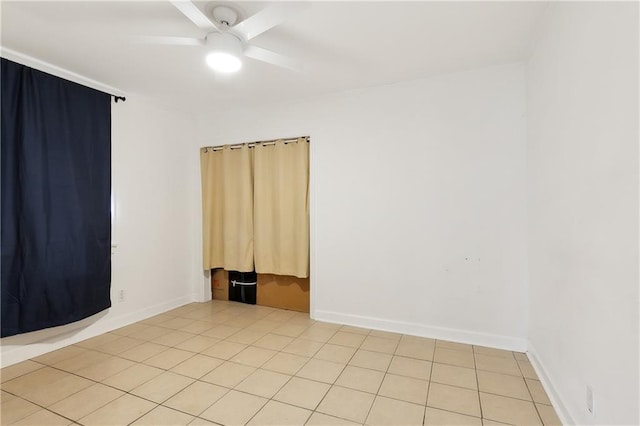 tiled spare room with ceiling fan