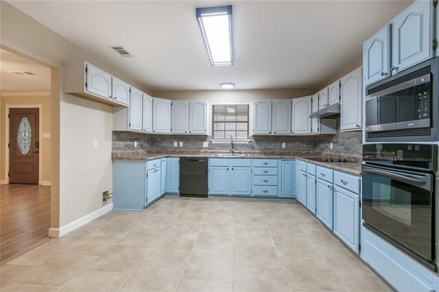 kitchen featuring sink, blue cabinets, tasteful backsplash, and black appliances