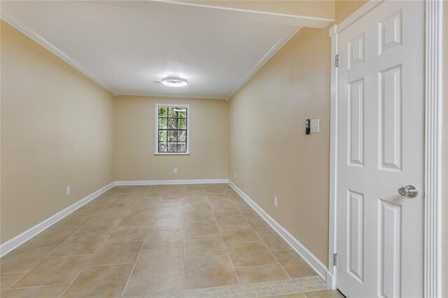 tiled empty room featuring crown molding