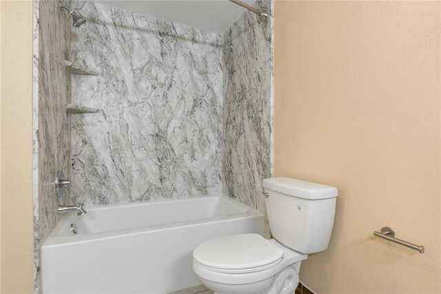 bathroom featuring washtub / shower combination and toilet