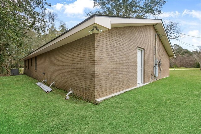 view of property exterior with a lawn and central AC