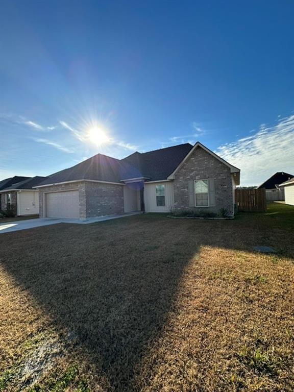 single story home featuring a garage and a front lawn