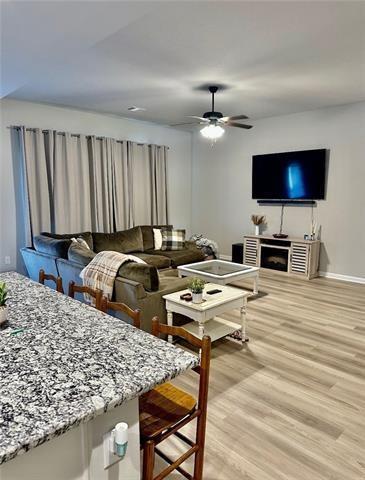 living room featuring hardwood / wood-style flooring, a fireplace, and ceiling fan