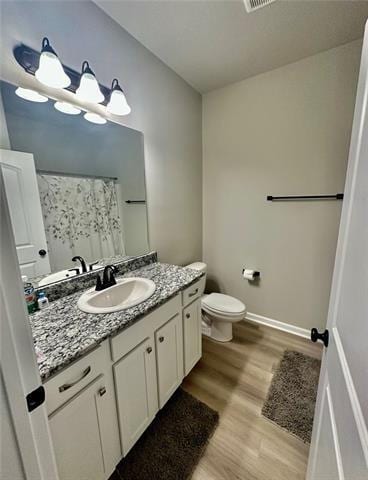 bathroom featuring hardwood / wood-style flooring, vanity, toilet, and a shower with curtain