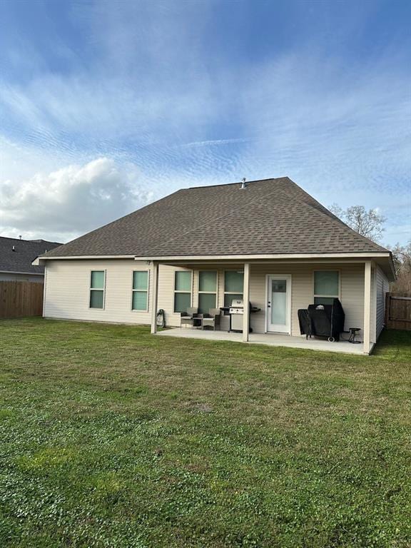 back of property with a lawn and a patio