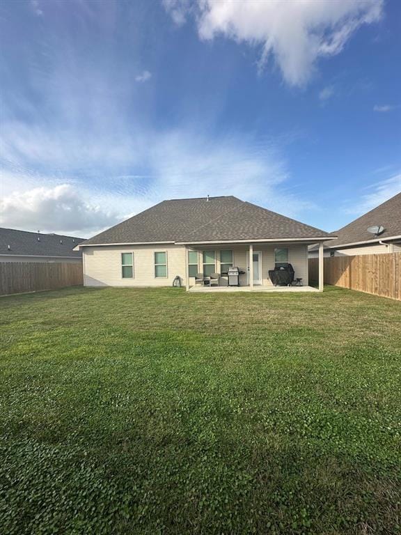 back of house with a lawn and a patio area