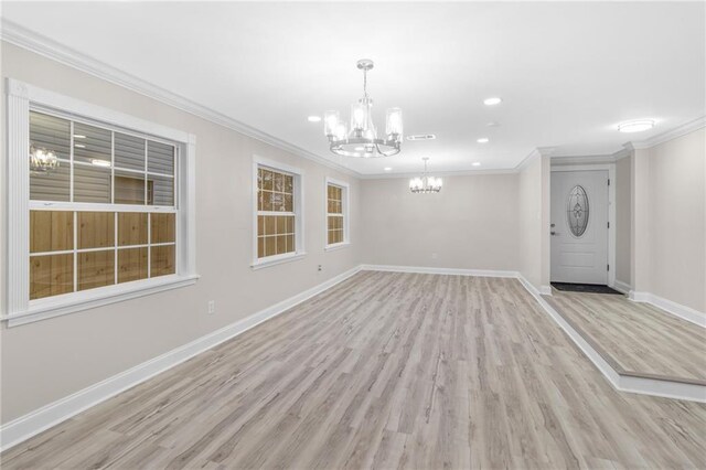 interior space featuring light hardwood / wood-style floors, ornamental molding, and a chandelier