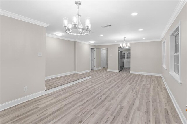 unfurnished living room with an inviting chandelier, ornamental molding, and light hardwood / wood-style flooring