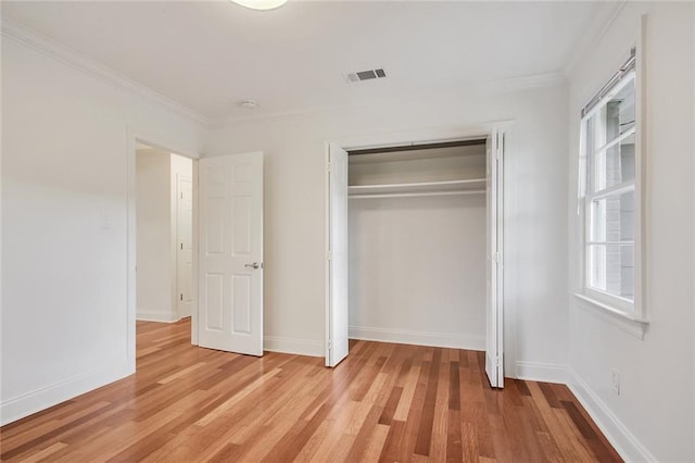 553 Crystal St, New Orleans, LA 70124 - unfurnished bedroom featuring baseboards, ornamental molding, a closet, and light wood finished floors