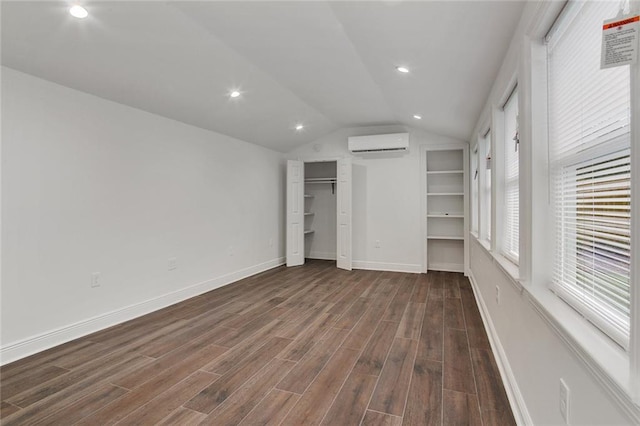 553 Crystal St, New Orleans, LA 70124 - unfurnished bedroom featuring dark wood-style floors, baseboards, recessed lighting, an AC wall unit, and vaulted ceiling