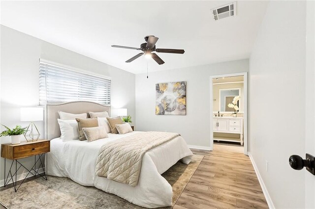 bedroom with ceiling fan, sink, hardwood / wood-style flooring, and ensuite bath